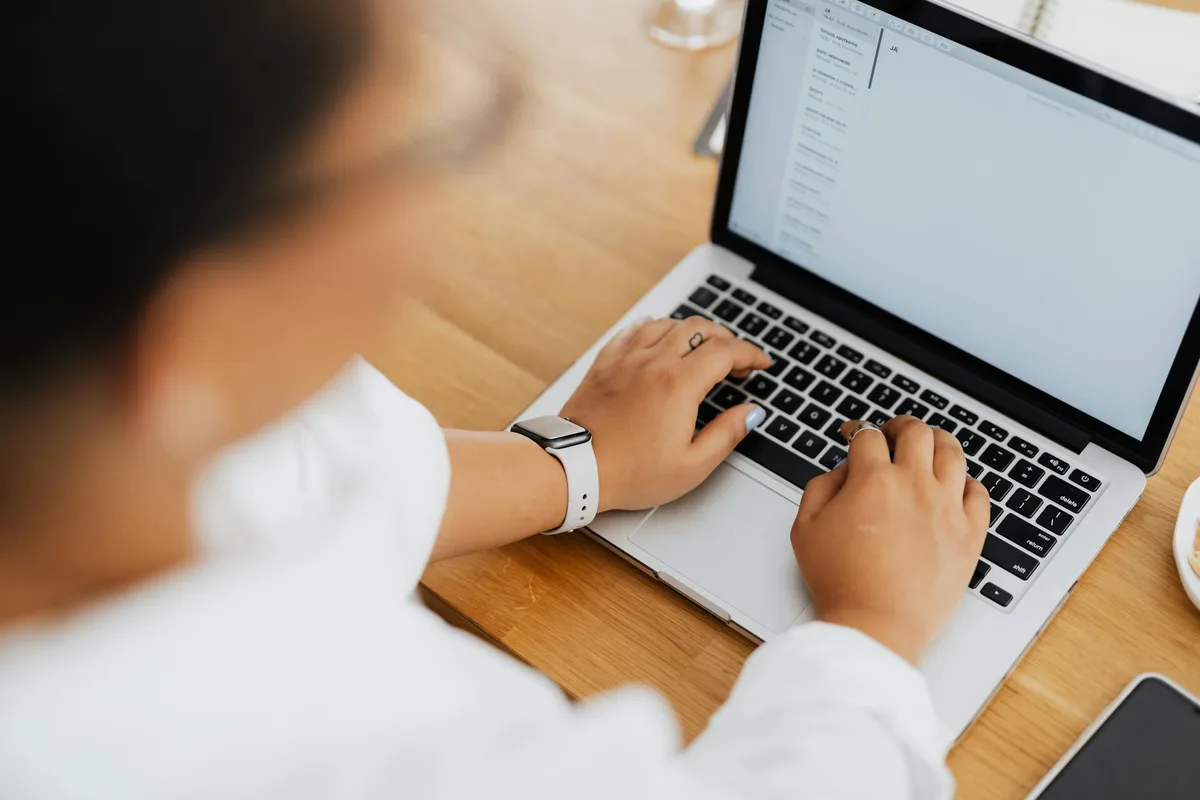A creator sitting at a desk with a laptop open to an email marketing dashboard, setting up automated lead magnet delivery for the first time