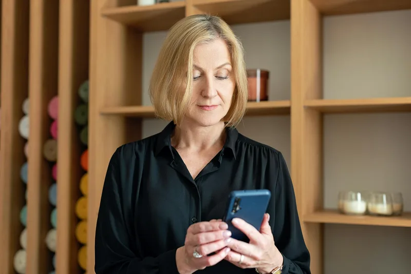 A person reviewing their email inbox on a smartphone, confirming that the lead magnet delivery email has arrived and the download link works correctly